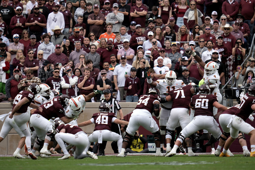 Miami defensive lineman Rueben Bain Jr. (4) blocks a field goal attemp by Texas A&M place kicker Jared Zirkel (99) during the second quarter in the first round of the NCAA College Football Playoff Saturday, Dec. 20, 2025, in College Station, Texas. (AP Photo/Sam Craft)