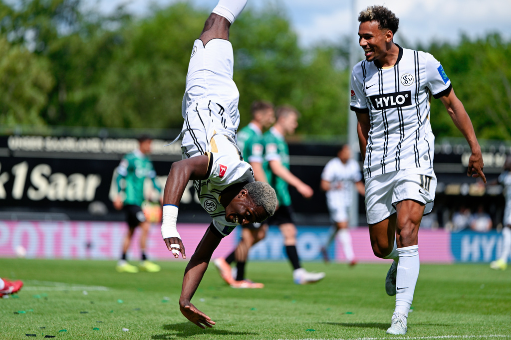 Elversberg's David Mokwa, left, celebrates scoring their second goal of the game with Bambase Conte during the Bundesliga 2 soccer match between SV Elversberg and SC Preußen Münster in Spiesen-Elversberg, Germany, Sunday May 17, 2026. (Uwe Anspach/dpa via AP)