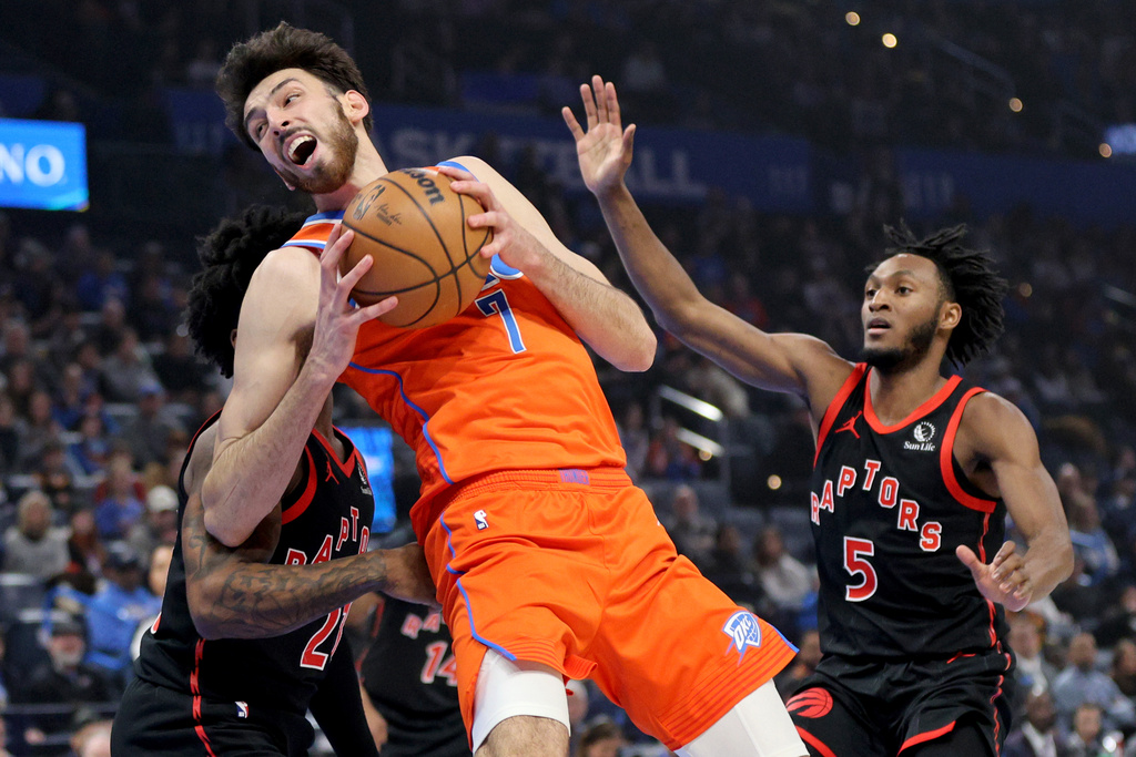 Oklahoma City Thunder center Chet Holmgren (7) works to get to the basket against Toronto Raptors guards Jamal Shead, left, and Immanuel Quickley (5) during the first half of an NBA basketball game Sunday, Jan. 25, 2026, in Oklahoma City. (AP Photo/Nate Billings)