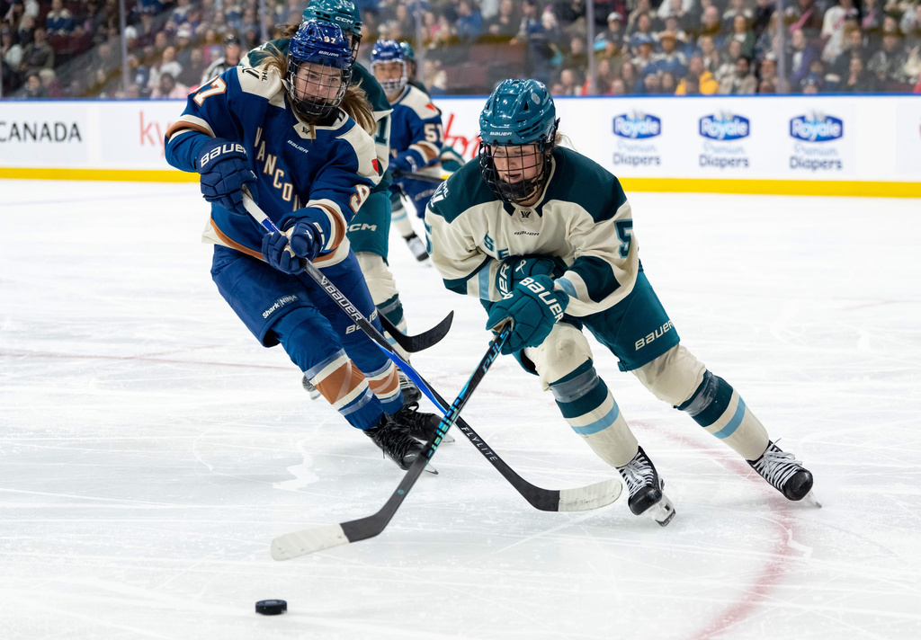 Vancouver Goldeneyes' Anna Shokhina (97) and Seattle Torrent's Anna Wilgren (5) vie for the puck during the third period of a PWHL hockey game in Vancouver, British Columbia, Tuesday, April 14, 2026. (Ethan Cairns/The Canadian Press via AP)