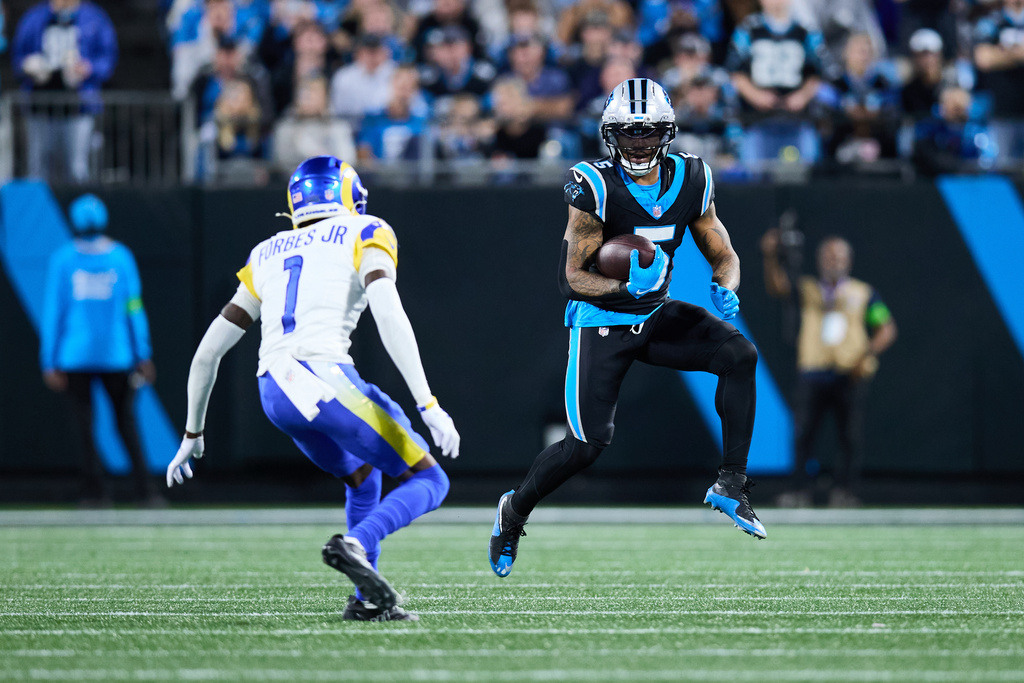 FILE - Carolina Panthers running back Rico Dowdle (5) looks to avoid Los Angeles Rams cornerback Emmanuel Forbes Jr. (1) during an NFL wild card playoff football game, on Jan. 10, 2026, in Charlotte, N.C. (AP Photo/Brian Westerholt, File)
