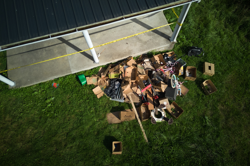 Debris is strewn on the front lawn of a home where authorities say they removed 16 children and arrested four adults in Hamden, Ohio, Wednesday, July 1, 2026. (AP Photo/Carolyn Kaster)