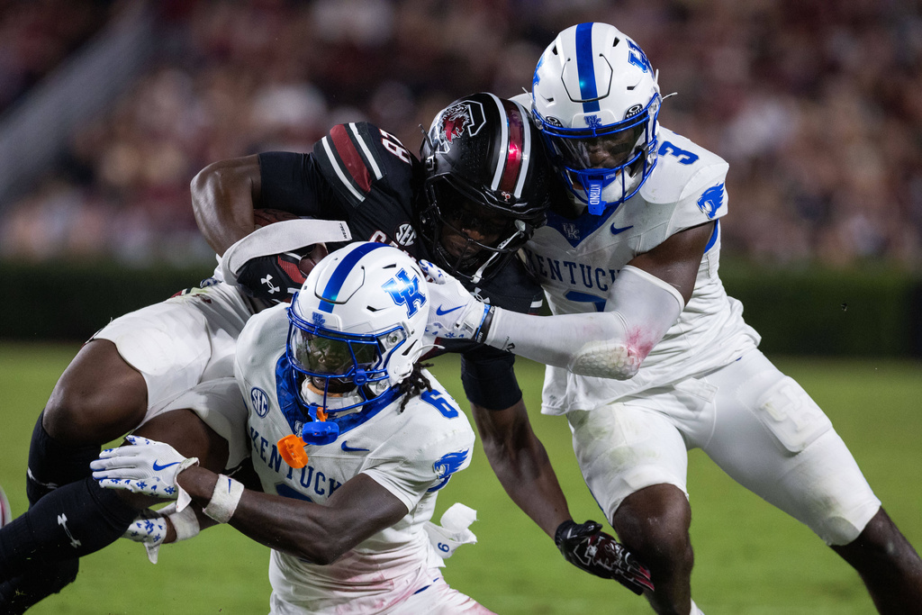 Kentucky defensive back JQ Hardaway (6) and linebacker Alex Afari Jr. (3) tackle South Carolina running back Matt Fuller (28) during the second half of an NCAA college football game, Saturday, Sept. 27, 2025, in Columbia, S.C. (AP Photo/Scott Kinser)