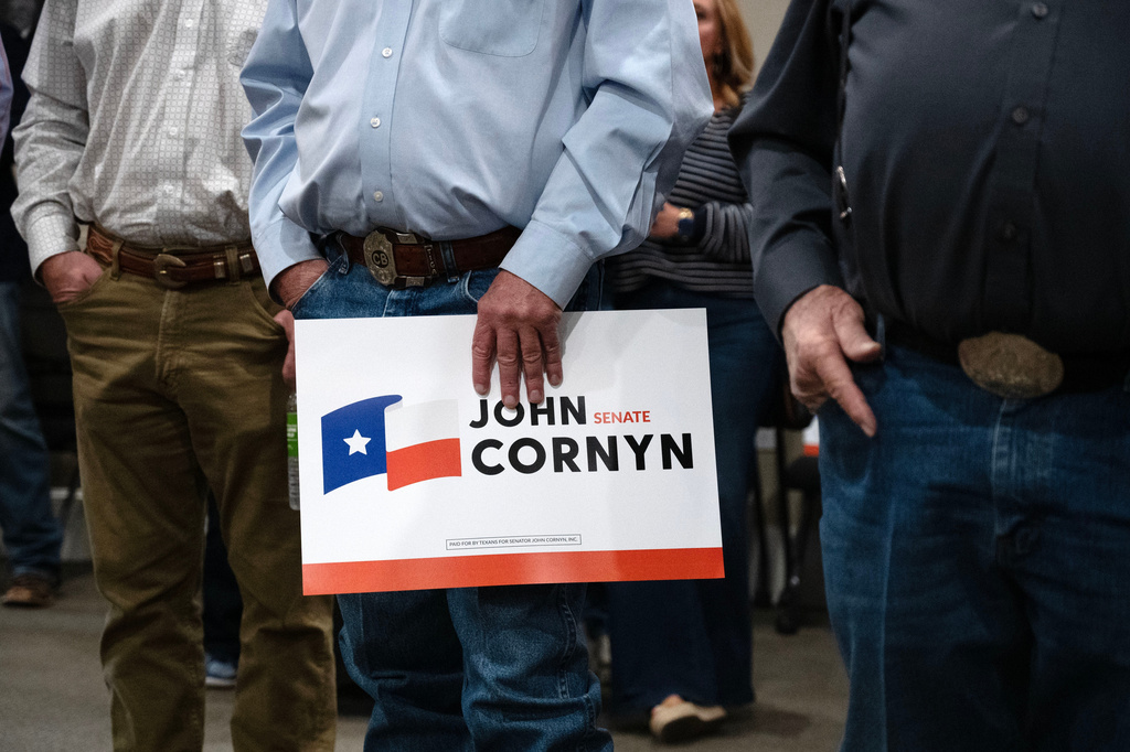Supporters holds a Sen. John Cornyn, R-Texas, sign during his campaign event in Lubbock, Texas, Tuesday, May 19, 2026. (AP Photo/Annie Rice)