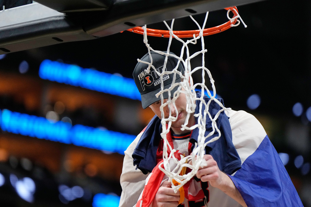 Illinois' Zvonimir Ivisic cuts part of the net after an Elite Eight game against Iowa in the NCAA college basketball tournament Saturday, March 28, 2026, in Houston. (AP Photo/Ashley Landis)