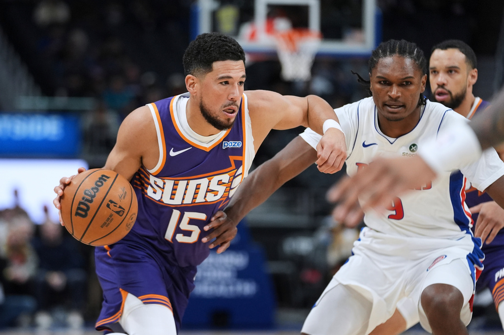 Phoenix Suns guard Devin Booker (15) drives on Detroit Pistons' Ausar Thompson (9) during the first half of a preseason NBA basketball game Monday, Oct. 5, 2026, in Detroit. (AP Photo/Paul Sancya)