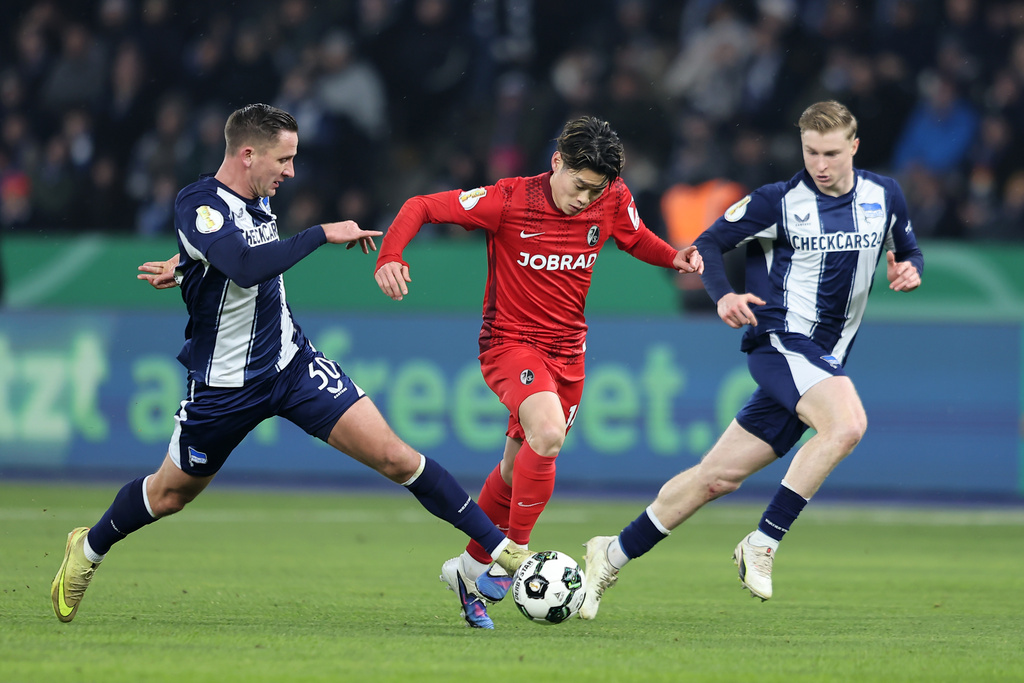 Freiburg's Yuito Suzuki, center, controls the ball.during the German Cup quarterfinal soccer match between Hertha Berlin and SC Freiburg in Berlin, Tuesday, Feb. 10, 2026. (Andreas Gora/dpa via AP)
