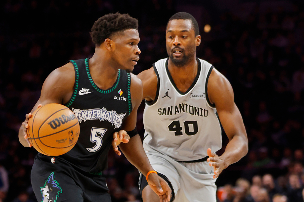 Minnesota Timberwolves guard Anthony Edwards (5) works around San Antonio Spurs forward Harrison Barnes (40) in the first quarter of an NBA basketball game Sunday, Nov. 30, 2025, in Minneapolis. (AP Photo/Bruce Kluckhohn)