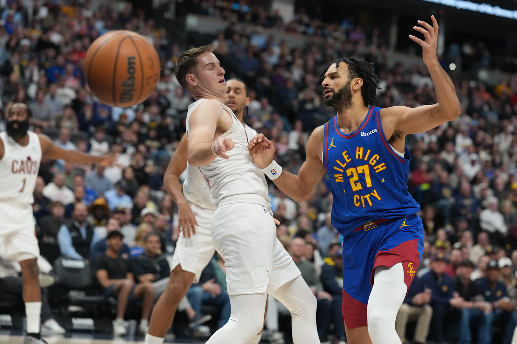 Cleveland Cavaliers guard Sam Merrill, left, fouls Denver Nuggets guard Jamal Murray as he drives to the net in the first half of an NBA basketball game Monday, Feb. 9, 2026, in Denver. (AP Photo/David Zalubowski)
