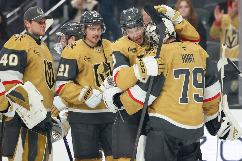 Vegas Golden Knights defenseman Brayden McNabb (3) and goaltender Carter Hart (79) hug after their shootout victory in an NHL hockey game against the Chicago Blackhawks Tuesday, Dec. 2, 2025, in Las Vegas. (AP Photo/Ian Maule)