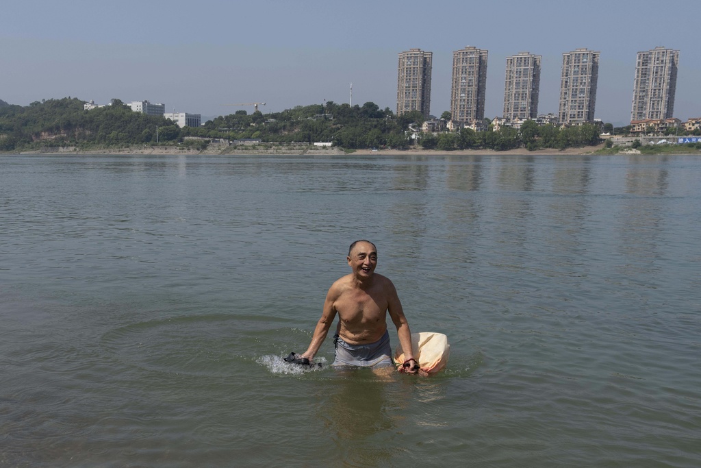 A elderly man wades in the water along the banks of the Yangtze River near Yichang in central China's Hubei province on June 16, 2025. (AP Photo/Ng Han Guan)
