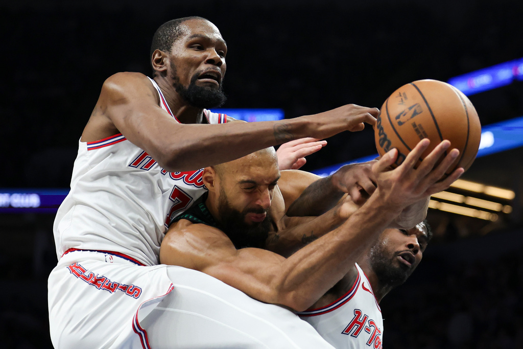 Houston Rockets forward Kevin Durant (7), Minnesota Timberwolves center Rudy Gobert, center, and Houston Rockets guard Amen Thompson, right, compete for a rebound during the first half of an NBA basketball game, Wednesday, March 25, 2026, in Minneapolis. (AP Photo/Ellen Schmidt)