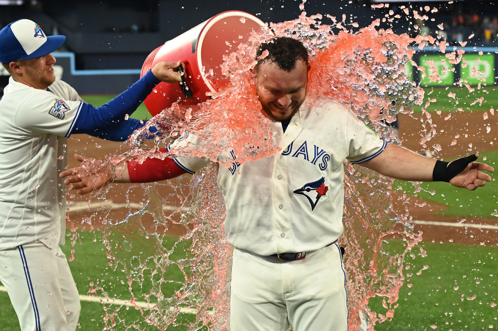 Toronto Blue Jays outfielder Myles Straw, left, douses teammate catcher Alejandro Kirk with a sports drink to celebrate their team's victory over the Houston Astros in a baseball game in Toronto, Monday, June 22, 2026. (Jon Blacker/The Canadian Press via AP)