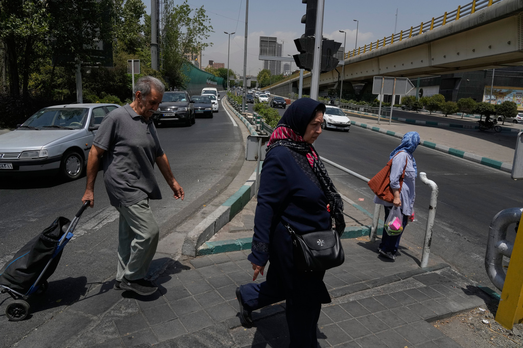 People cross a street in Tehran, Iran, Tuesday, July 21, 2026. (AP Photo/Vahid Salemi)