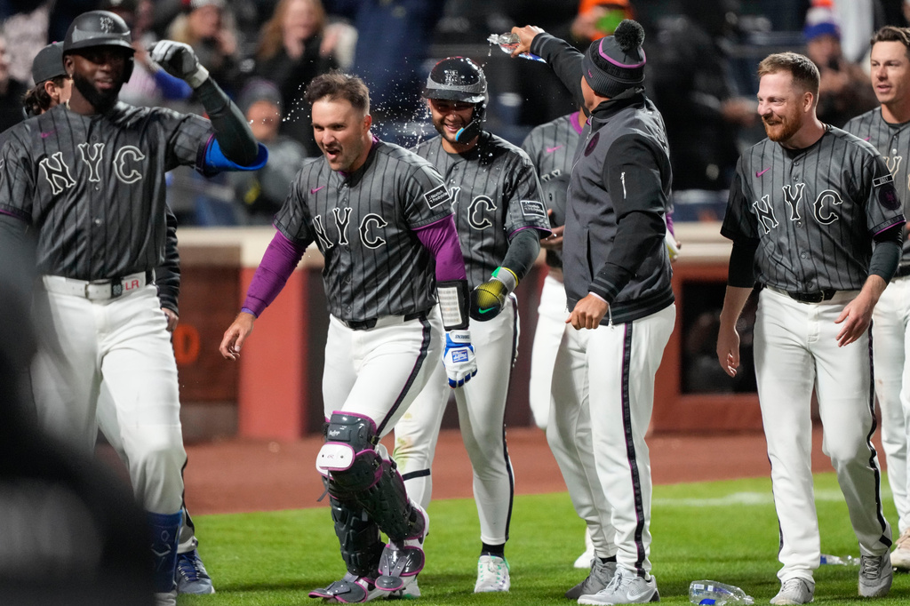 New York Mets shortstop Bo Bichette (19) celebrates with teammates after scoring during the eleventh inning of a baseball game against the Pittsburgh Pirates, Saturday, March 28, 2026, in New York. (AP Photo/Yuki Iwamura)