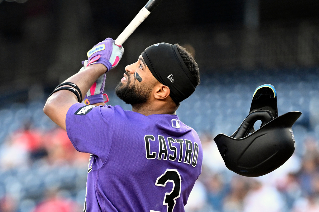 Colorado Rockies' Willi Castro looses his batting helmet as he hits a pop up to left field for an out during the first inning of a baseball game against the Washington Nationals, Wednesday, Aug. 26, 2026, in Washington. (AP Photo/John McDonnell)