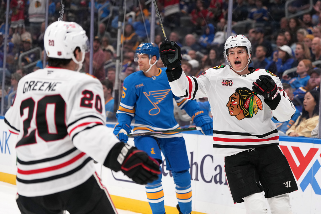 Chicago Blackhawks' Lukas Reichel, right, is congratulated by teammate Ryan Greene (20) after scoring as St. Louis Blues' Colton Parayko, center, skates in the background during the first period of an NHL hockey game Wednesday, Oct. 15, 2025, in St. Louis. (AP Photo/Jeff Roberson)