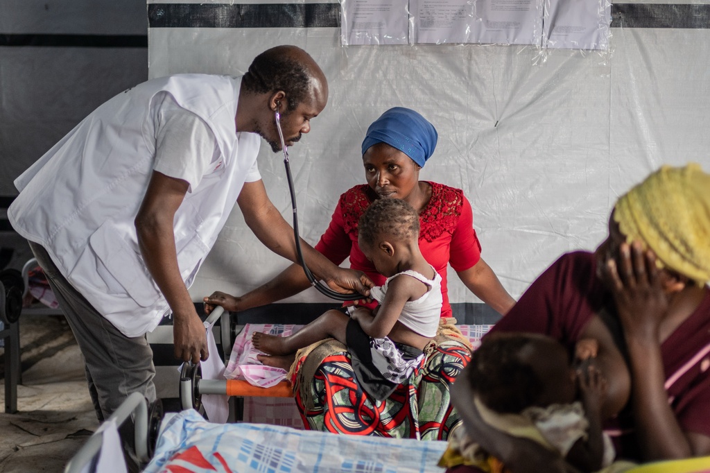 Dr. Toussaint Selemani checks a child with measles at the Kachehembe health center, in Rubaya, eastern Democratic Republic of Congo, Monday, Dec. 1, 2025. (AP Photo/Moses Sawasawa)