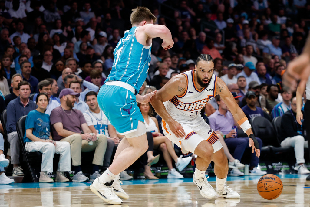 Phoenix Suns forward Dillon Brooks, right, drives against Charlotte Hornets guard Kon Knueppel during the first half of an NBA basketball game in Charlotte, N.C., Thursday, April 2, 2026. (AP Photo/Nell Redmond)