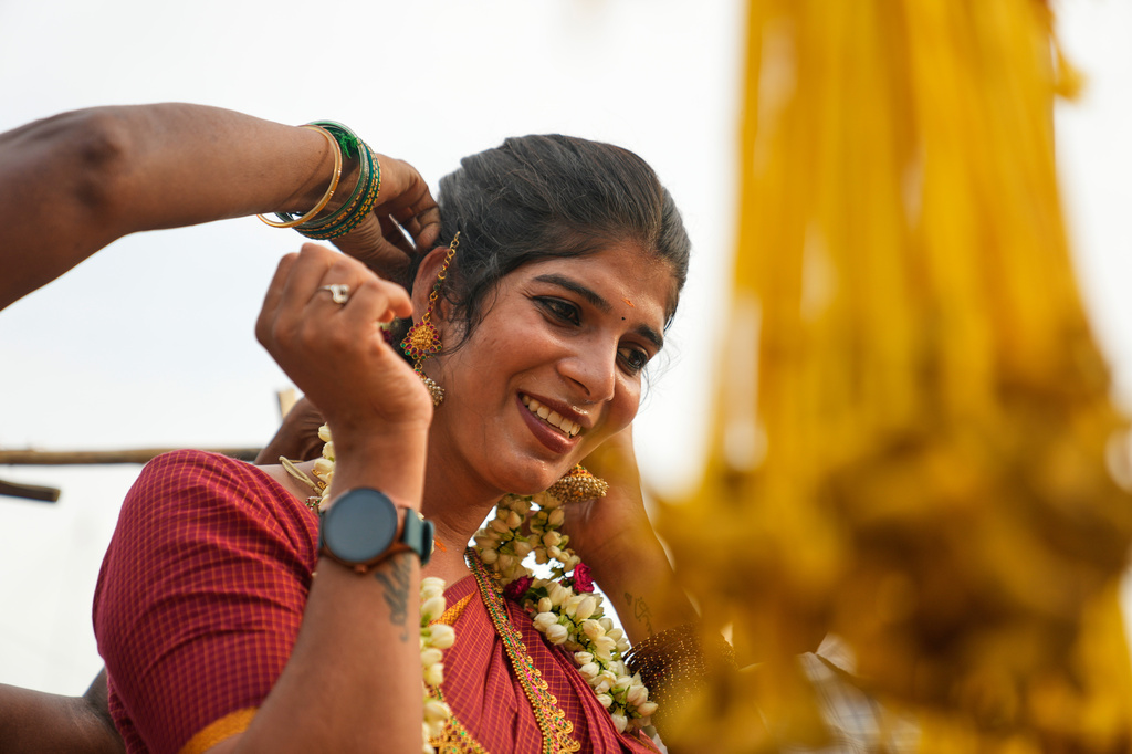 A shopkeeper places flowers in the hair of Nazariya Kutty during the Koovagam transgender festival in the Kallakurichi districtin the southern Indian state of Tamil Nadu, Tuesday, April 28, 2026. (AP Photo/Mahesh Kumar A.)