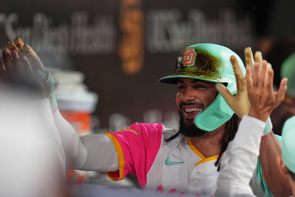 San Diego Padres' Fernando Tatis Jr. celebrates with teammates in the dugout after hitting a grand slam during the fourth inning of a baseball game against the Arizona Diamondbacks Friday, Sept. 26, 2025, in San Diego. (AP Photo/Gregory Bull)