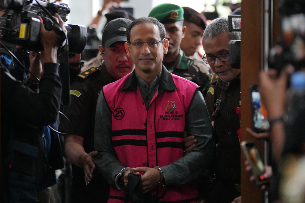 Nadiem Anwar Makarim, center, the co-founder of Indonesia's payments platform and ride hailing company Gojek and former education minister, enters the courtroom for his first trial hearing at the Corruption Court in Jakarta, Indonesia, Monday, Jan. 5, 2026. (AP Photo/Tatan Syuflana)