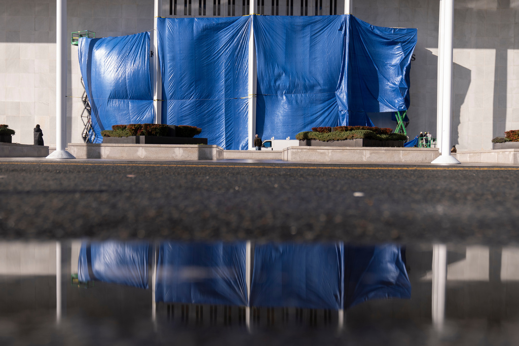 Tarps are installed in front of the sign on the Kennedy Center on Friday, Dec. 19, 2025, in Washington. (AP Photo/Mark Schiefelbein)