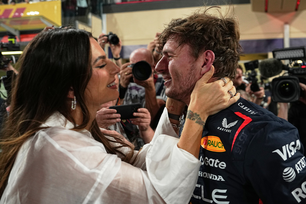Red Bull driver Max Verstappen of the Netherlands, right, kisses his girlfriend Kelly Piquet after clocked the fastest time during the qualifying session ahead of the Formula One Abu Dhabi Grand Prix at the Yas Marina Circuit in Abu Dhabi, UAE, Saturday, Dec. 6, 2025. (AP Photo/Fatima Shbair)