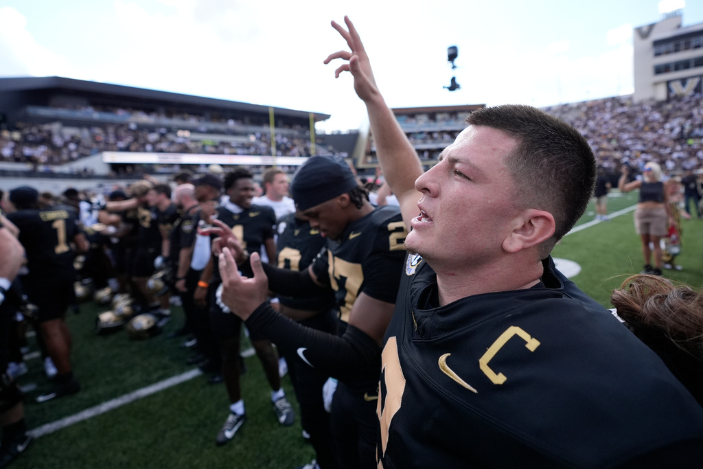 Vanderbilt quarterback Diego Pavia, right, celebrates the team's win with teammates after an NCAA college football game against LSU, Saturday, Oct. 18, 2025, in Nashville, Tenn. (AP Photo/George Walker IV)