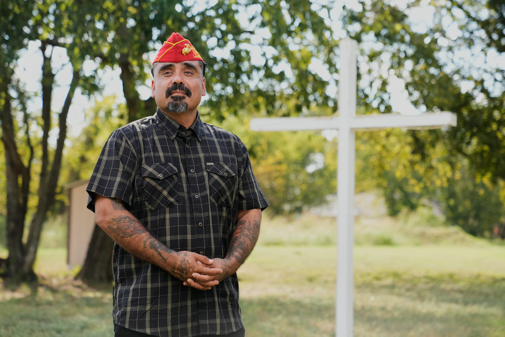Julio Torres poses for a photo by a cross in an open field, Monday, Sept. 22, 2025, in Terrell, Texas. (AP Photo/Tony Gutierrez)