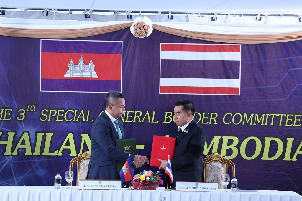In this photo released by Agence Kampuchea Press (AKP), Cambodian Defense Minister Tea Seiha, left, stands with Thai Defense Minister Natthaphon Narkphanit, right, at the General Border Committee Meeting in Chanthaburi Province, Thailand Saturday, Dec. 27, 2025. (AKP via AP) g