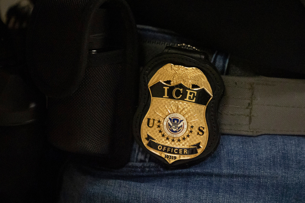 FILE - A federal agent wears a badge of Immigration and Customs Enforcement while standing outside an immigration courtroom at the Jacob K. Javits Federal Building in New York, June 10, 2025. (AP Photo/Yuki Iwamura, File)