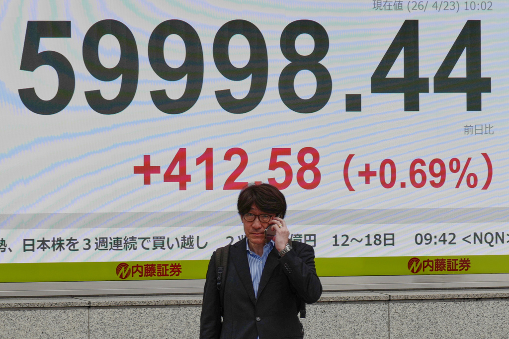 A person walks in front of an electronic stock board showing Japan's Nikkei index at a securities firm Thursday, April 23, 2026, in Tokyo. (AP Photo/Eugene Hoshiko)
