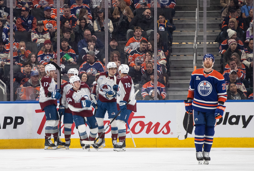 Colorado Avalanche players celebrate a goal as Edmonton Oilers' Brett Kulak (27) skates past during second period of an NHL game, in Edmonton on Saturday, Nov. 8, 2025. (Jason Franson/The Canadian Press via AP)