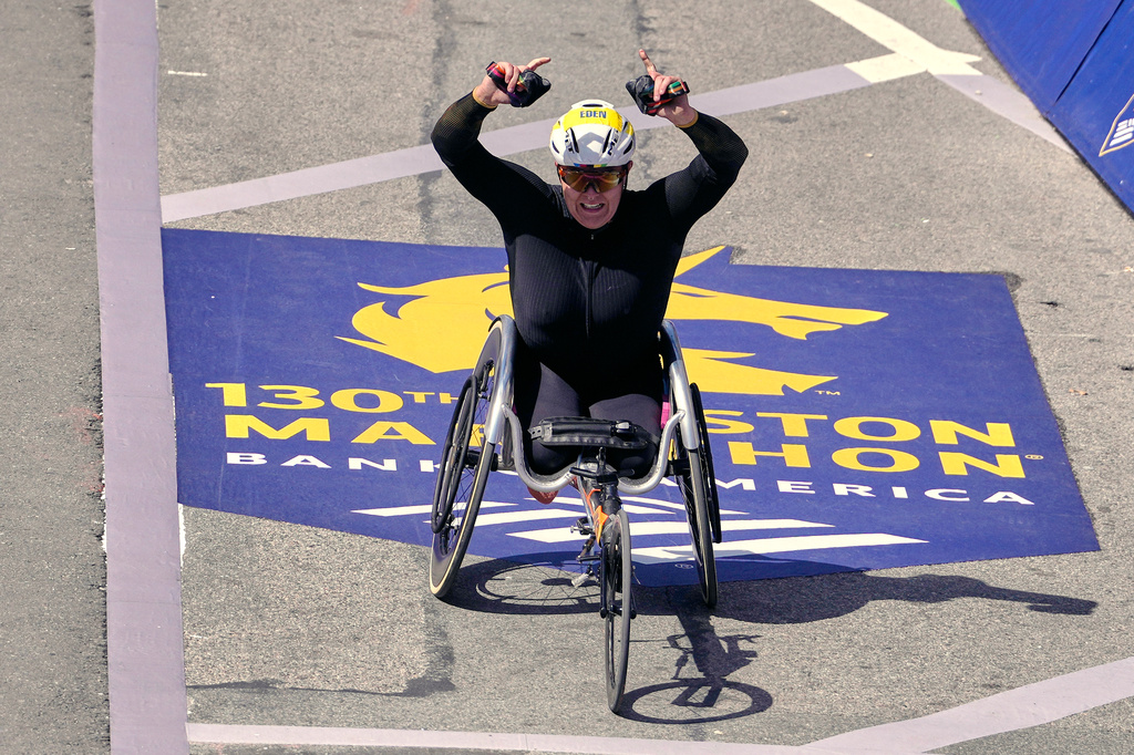 Eden Rainbow-Cooper, of Portsmouth, England, raises her arms while approaching the finish line while winning the women's wheelchair division of the Boston Marathon, Monday, April 20, 2026, in Boston. (AP Photo/Charles Krupa)