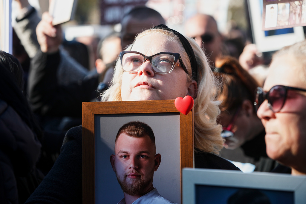 A woman holds a picture of a Kocani nightclub fire victim during a protest in Skopje, North Macedonia, on Saturday, Nov. 15, 2025, just a few days before the start of the trial for the fire. (AP Photo/Boris Grdanoski)