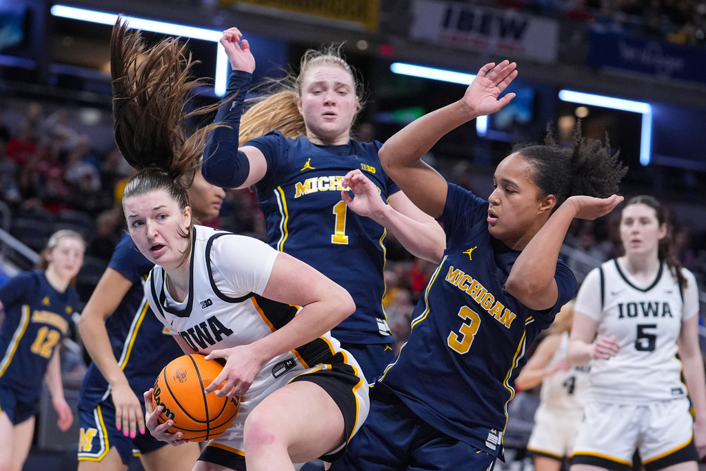 Iowa guard Taylor Stremlow (1) grabs a rebound in front of Michigan guard Olivia Olson (1) and guard Mila Holloway (3) in the second half of an NCAA college basketball game in the semifinals of the Big Ten Conference tournament, Saturday, March 7, 2026 in Indianapolis. (AP Photo/Michael Conroy)