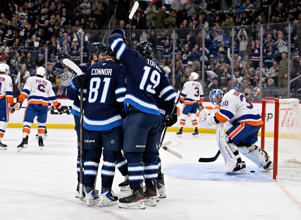 Winnipeg Jets' Jonathan Toews (19) celebrates his goal on New York Islanders goaltender Ilya Sorokin (30) with Kyle Connor (81) and teammates during the second period of their NHL hockey game, in Winnipeg, Manitoba, Tuesday Jan. 13, 2026. (Fred Greenslade/The Canadian Press via AP)