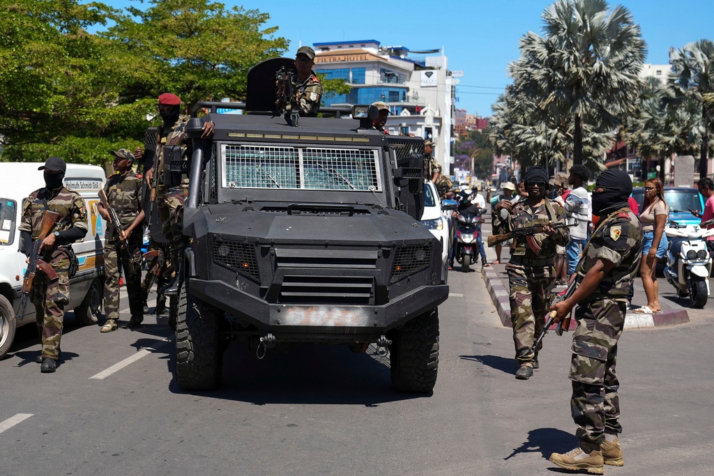 Soldiers are greeted by people gathering for a ceremony in tribute to demonstrators killed during recent anti-government protest in Antananarivo, Madagascar, Sunday, Oct. 12, 2025. (AP Photo/Mamyrael)