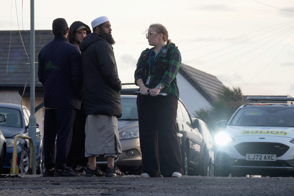 Locals view the damage outside the front entrance of the mosque in Peacehaven, following a suspected arson attack, in East Sussex, England, Sunday, Oct. 5, 2025. (Jamie Lashmar/PA via AP)