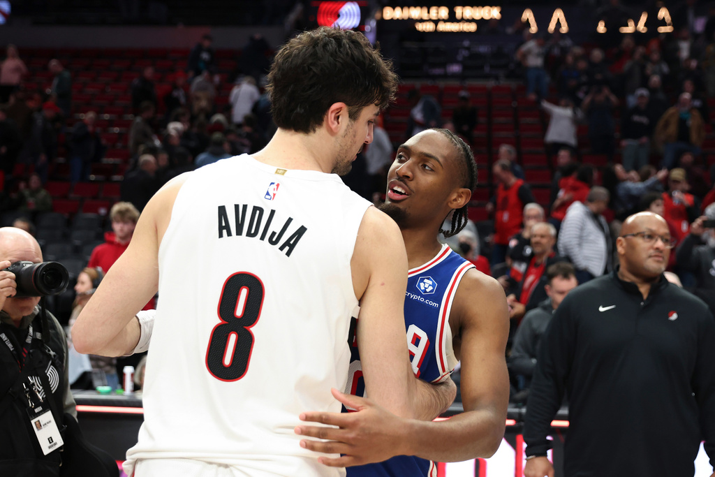 Portland Trail Blazers forward Deni Avdija (8) and Philadelphia 76ers guard Tyrese Maxey (0) hug following an NBA basketball game Monday, Feb. 9, 2026, in Portland, Ore. (AP Photo/Amanda Loman)