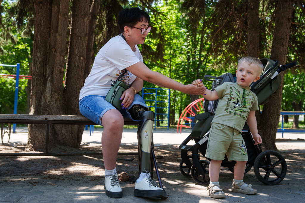 Iryna Nakonechna plays with her grandson Tymofii in a park of Kryvyi Rih, Ukraine, Saturday, May 9, 2026. (AP Photo/Evgeniy Maloletka)