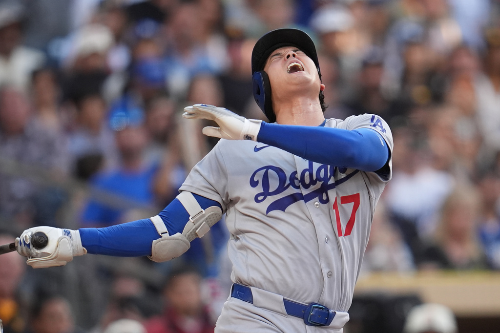 Los Angeles Dodgers' Shohei Ohtani reacts after being hit with a foul ball while batting as San Diego Padres catcher Freddy Fermin looks onduring the fifth inning of a baseball game Wednesday, May 20, 2026, in San Diego. (AP Photo/Gregory Bull)