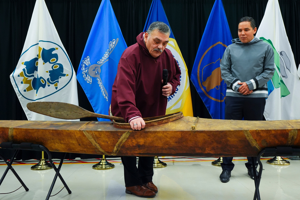 Darrel Nasogaluak, Elder and Chair of Tuktoyaktuk Community Corp., middle, answers questions with Natan Obed, President of Inuit Tapiriit Kanatami, as a selection of Inuit items, including a traditionally built Inuvialuit kayak, are unveiled at the Canadian Museum of History in Gatineau, Que., on Tuesday, Dec. 9, 2025. (Sean Kilpatrick /The Canadian Press via AP)