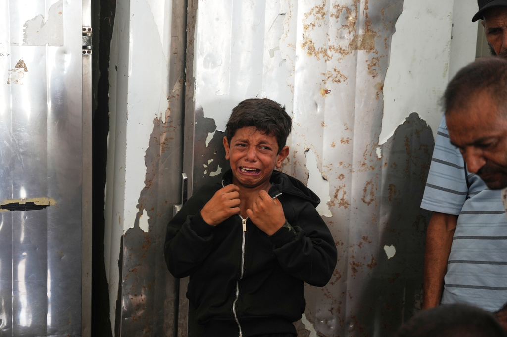 A Palestinian boy cries over the body of Hamouda al-Attar, who was killed by the Israeli army, during his funeral at al-Aqsa Hospital in Deir al-Balah, central Gaza Strip, Saturday, Aug. 29, 2026. (AP Photo/Abdel Kareem Hana)