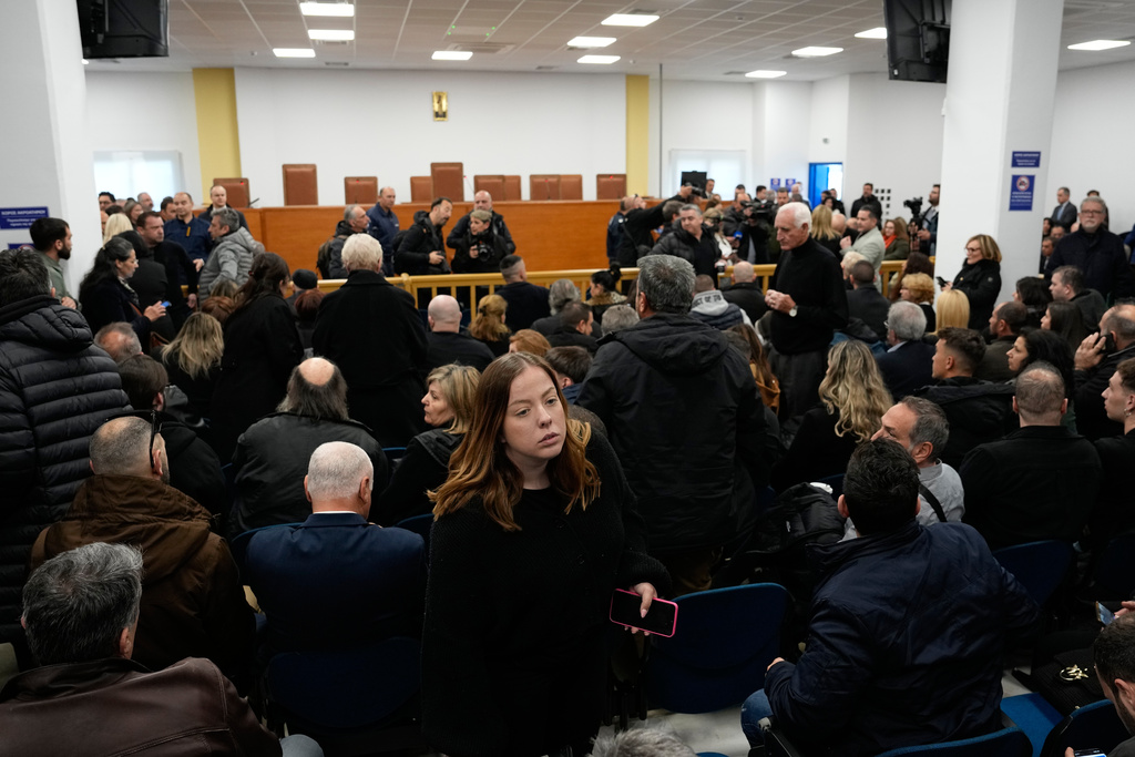 Relatives of victims of the Tempi train crash, wait for the start of the trial at the court in Larissa, Greece, Monday, March 23, 2026. (AP Photo/Thanassis Stavrakis)