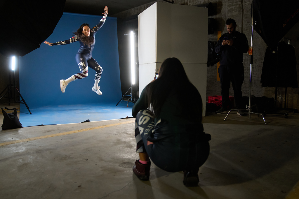 Skier Jackie Wiles, left, of Portland, jumps for a fun photo being taken by skier Bella Wright, 28, of Salt Lake City, between shoots by the team photographer in a makeshift photo studio in an underground parking garage at Copper Mountain, Colo., Nov. 19, 2025. (AP Photo/Jacquelyn Martin)