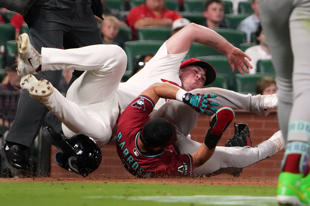 Arizona Diamondbacks' Jorge Barrosa, right, scores past St. Louis Cardinals pitcher Gordon Graceffo (44) on a passed ball during the ninth inning of a baseball game Tuesday, June 23, 2026, in St. Louis. (AP Photo/Jeff Roberson)