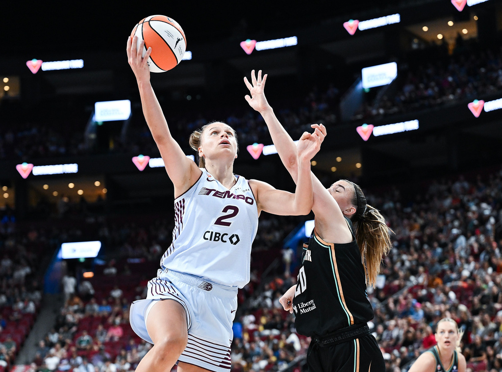 Toronto Tempo's Laura Juskaite (2) goes up for a basket as New York Liberty's Sabrina Ionescu, second from left, defends during the first half of a WNBA basketball game in Montreal, Sunday, July 12, 2026. (Graham Hughes/The Canadian Press via AP)
