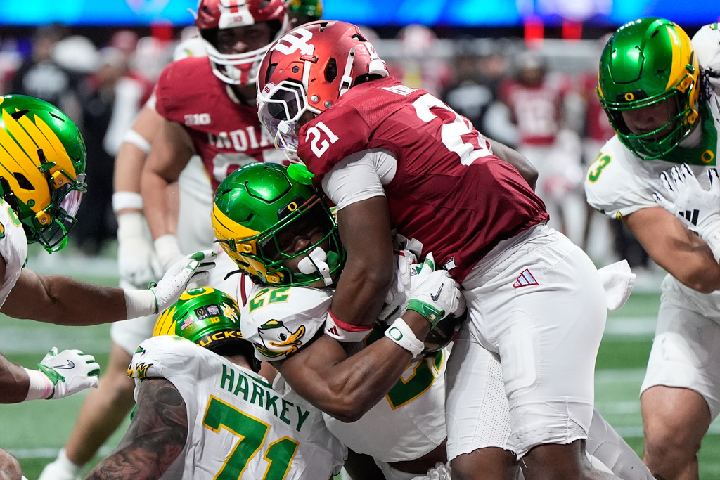 Oregon running back Jay Harris (22) carries for a touchdown against Indiana linebacker Rolijah Hardy (21) during the second half of the Peach Bowl NCAA college football playoff semifinal, Friday, Jan. 9, 2026, in Atlanta. (AP Photo/Brynn Anderson)